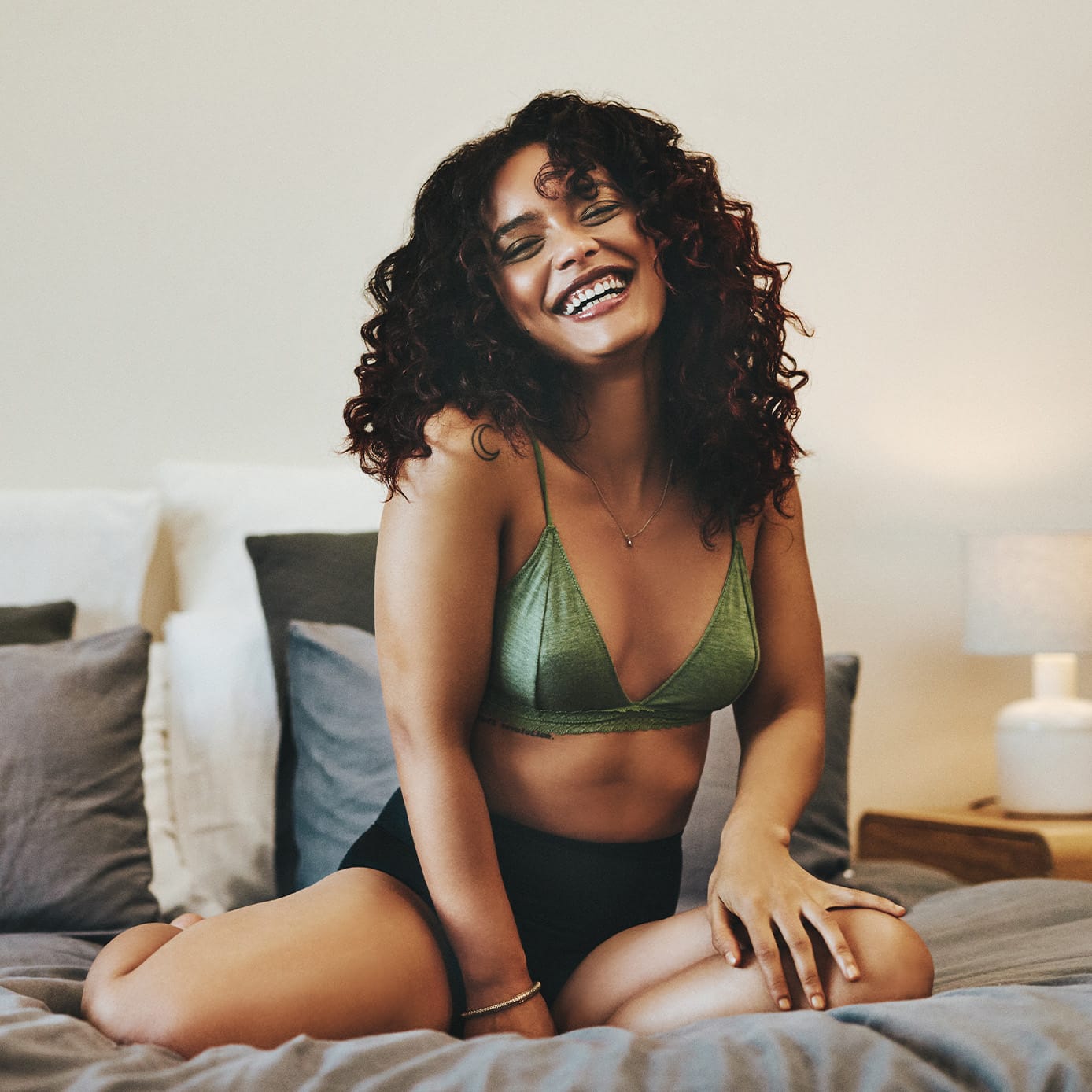 Woman sitting on a bed smiling