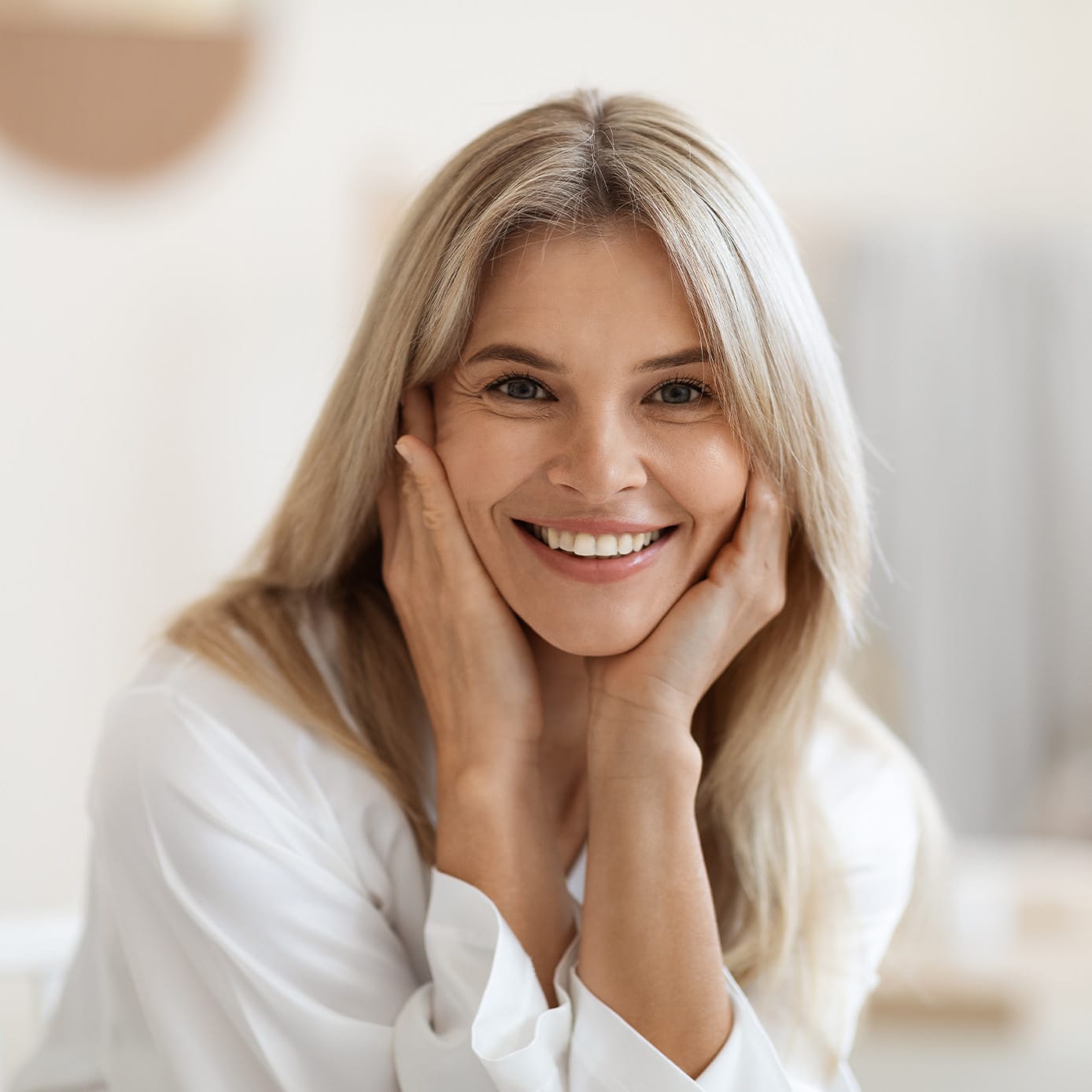 Woman smiling with hands on face
