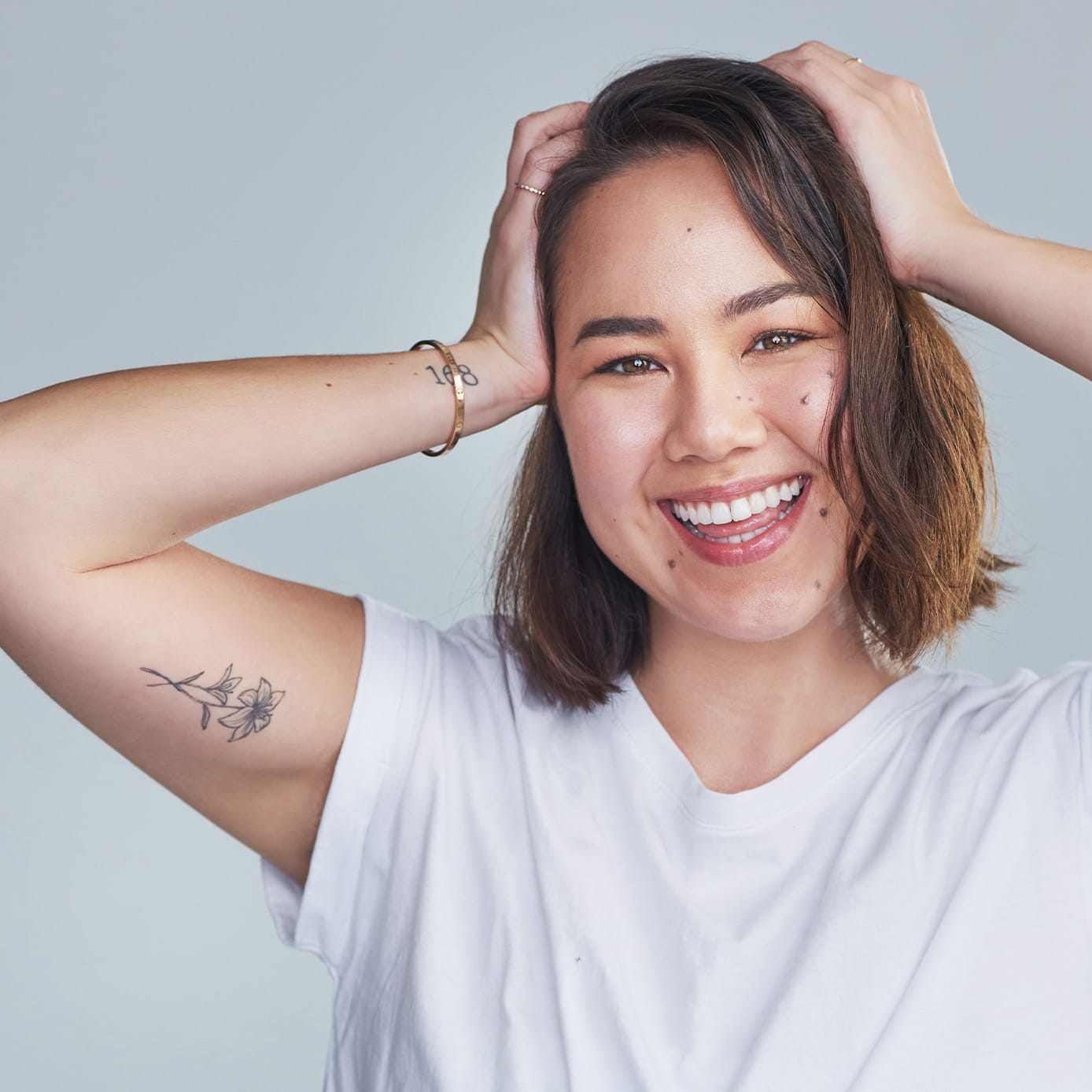 Woman smiling with hands on head